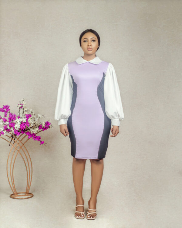 a model standing in lilac collared illusion sheath dress by Ria Kosher