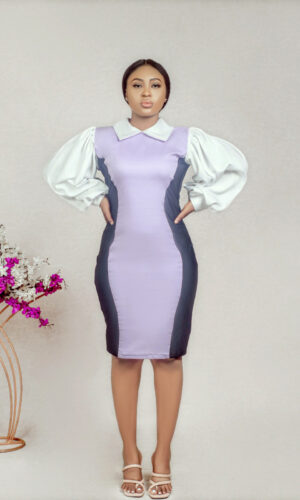 a model standing at akimbo in lilac collared illusion sheath dress by Ria Kosher
