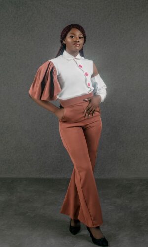 Victoria wearing brown and white mono-sleeve two-piece front view
